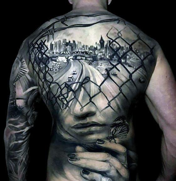 Full Back City Skyline With Chain Fence And Female Portrait Great Tattoo Design On Man