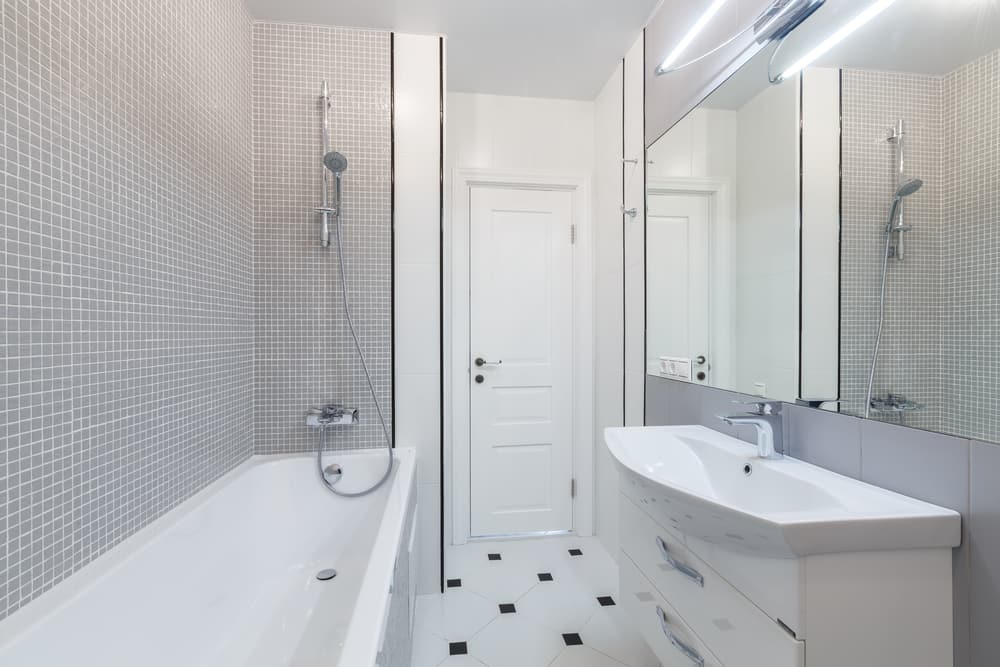 spacious white bathroom with grey tiled wall