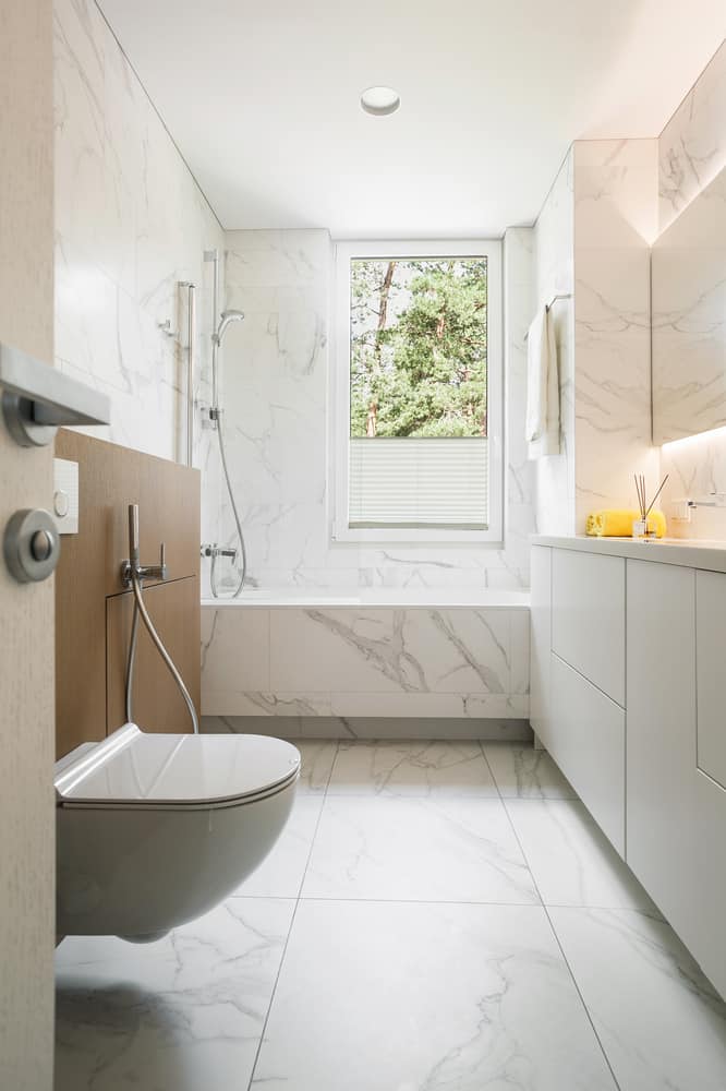 marble bathroom with toilet shower combo 