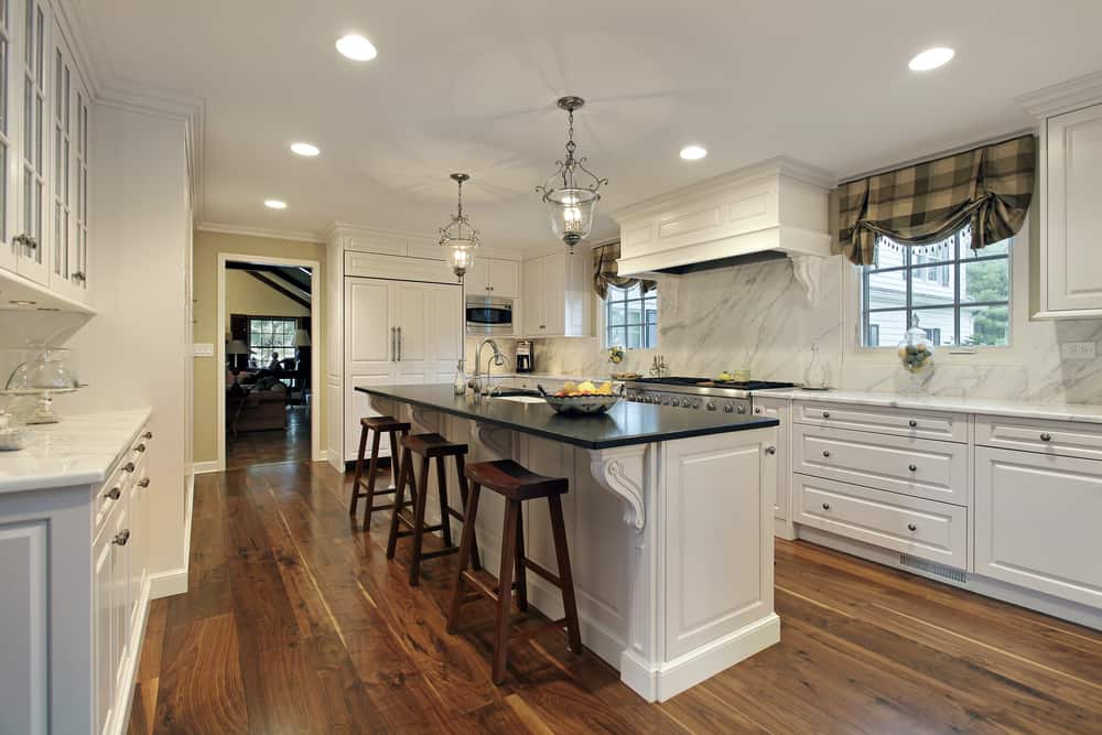 white kitchen hardwood floors island with black granite countertop 