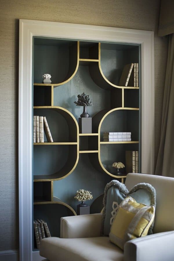 Elegant built-in shelves with a geometric gold and teal design, styled with books and decor.
