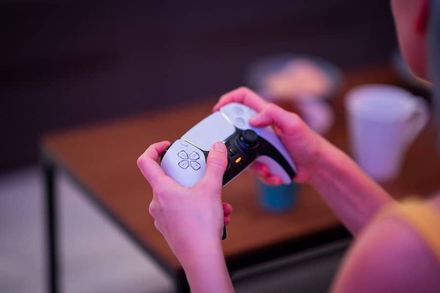girl gamer's hands playing video game on Playstation