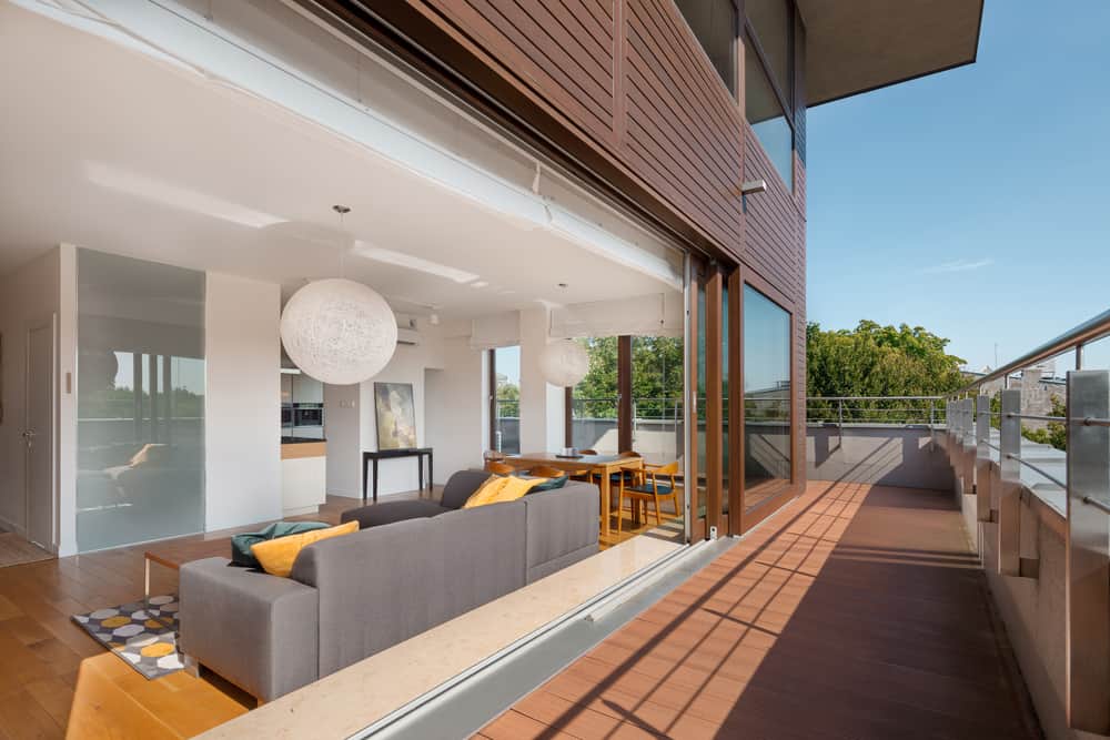 modern luxury enclosed patio wood deck gray sofa city view