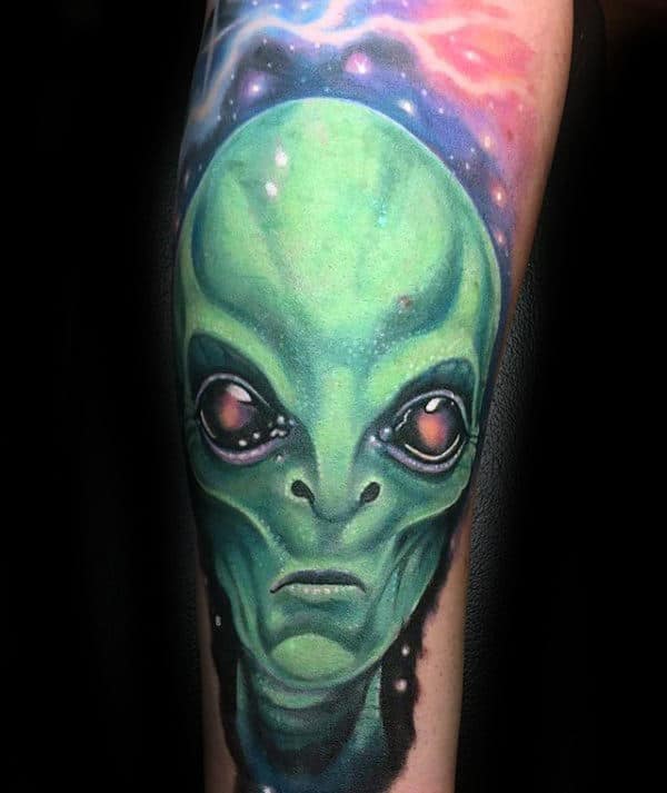 Glowing Green Alien With Outer Space Background Tattoo On Man