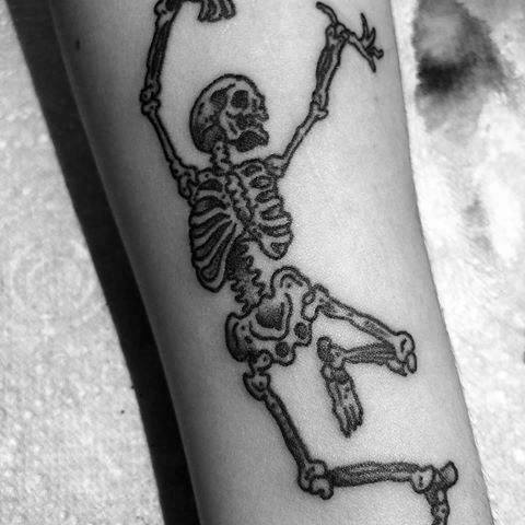 SIngle needle dancing skeleton tattoo located on the
