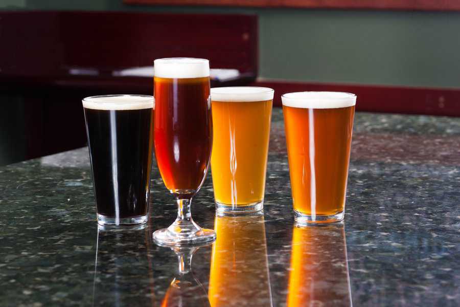 four pints of beer on granite slab bar