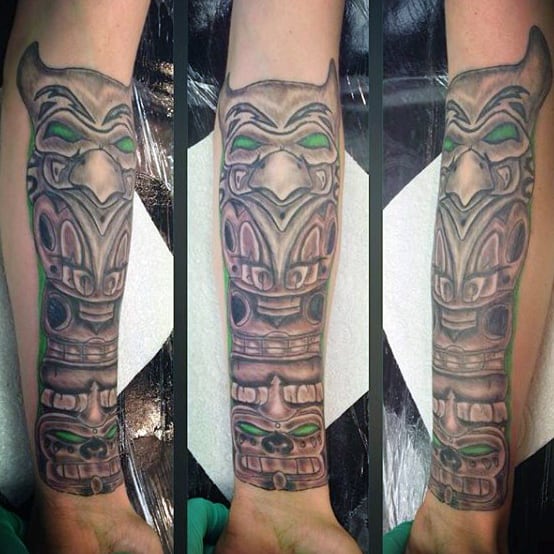 Green Outlined Traditional Totem Pole Tattoo On Gentleman