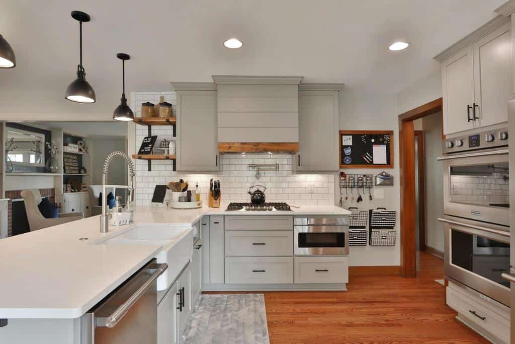 grey farmhouse kitchen hardwood floors two ovens white tile splashback