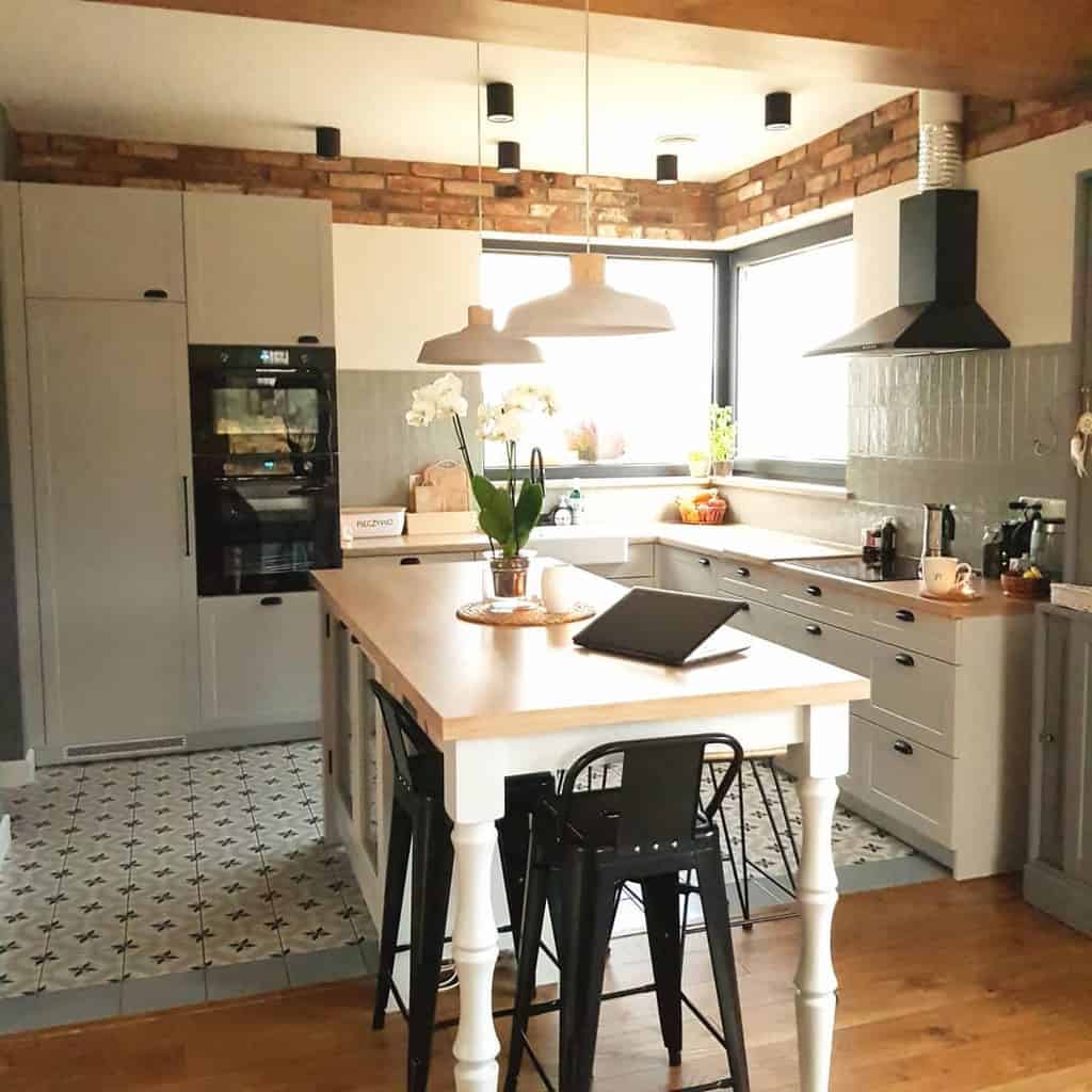 grey farmhouse kitchen white table with black chairs pendant lights pattern tile floor