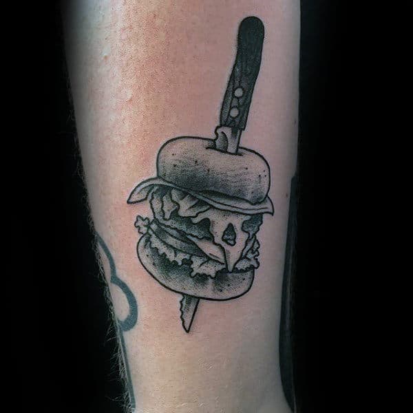 Grey Food Tattoo On Male Forearms Of Knife Slicing Through Burger