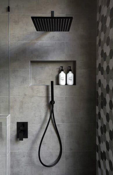 Modern shower with gray tiles, black fixtures, and a recessed niche for toiletries.