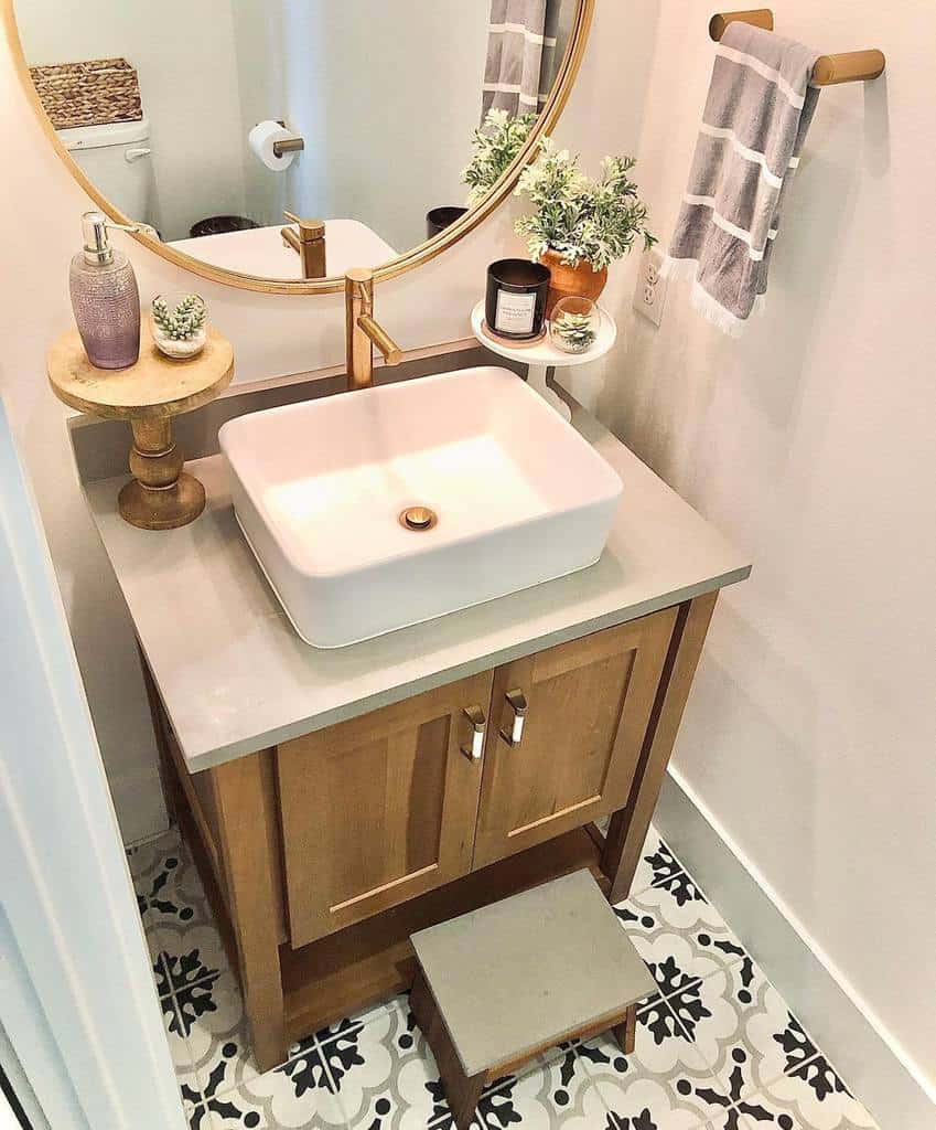 modern bathroom white sink wood vanity gold accent mirror pattern floor tiles 