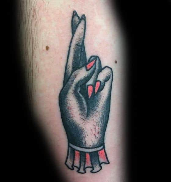 Crossed fingers tattoo on the inner forearm