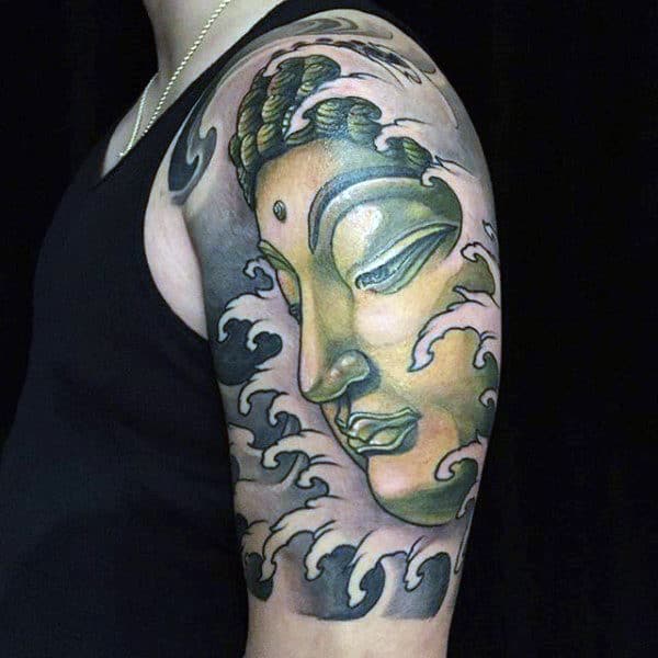 Guy With Green Buddha Face Tattoo On Arms