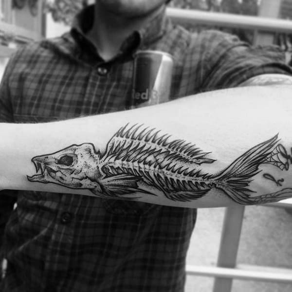 Guy With Outer Forearm Tattoo Design Of Fish Skeleton