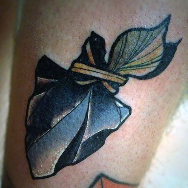 Guy With Pale Colored Arrowhead Tattoo On Legs
