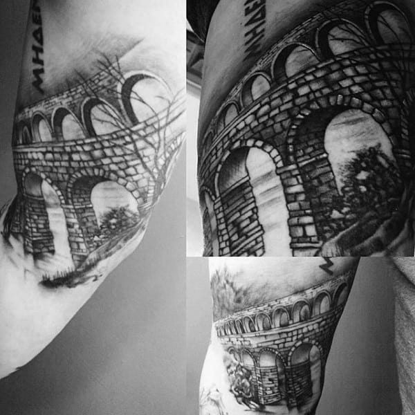 Guy With Stone Bridge Tattoo On Arm