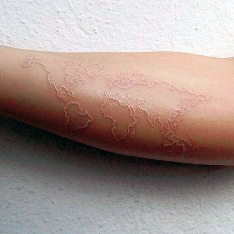 Guy With World Map White Ink Tattoo On Bicep