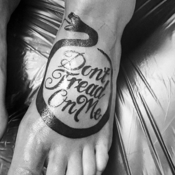 Guys Foot Tattoo Of Snake Surrounding Dont Tread On Me Text In Black Ink