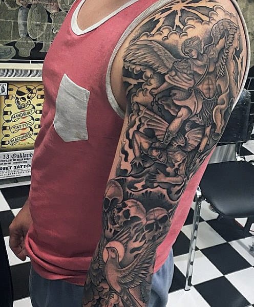 St. Michael tattoo sleeve on man's arm featuring skulls, angels and birds