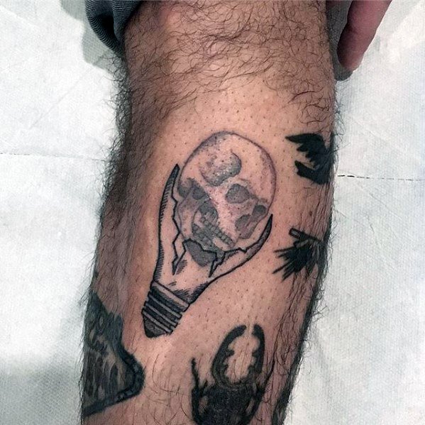 Guys Simple Lightbulb Skull Side Of Leg Tattoo