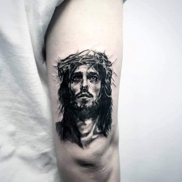 Guys Small Jesus Portrait Tattoo On Back Of Upper Arm
