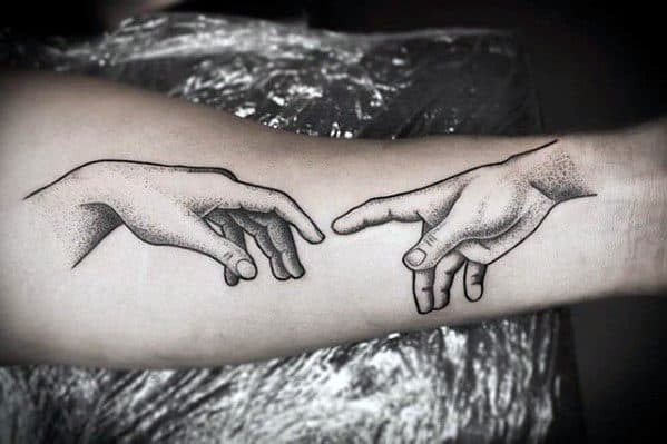 Hands from The Creation of Adam tattooed on the inner