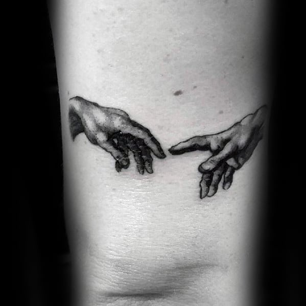 The hands from The Creation of Adam tattooed on rib