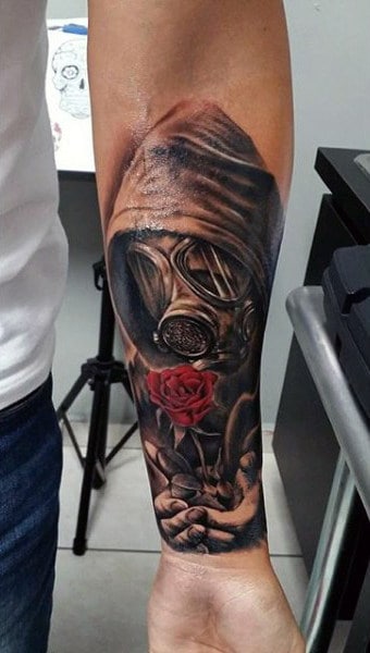 Guys Wrist Tattoo Of Man In Gas Mask Holding Red Color Rose Flower