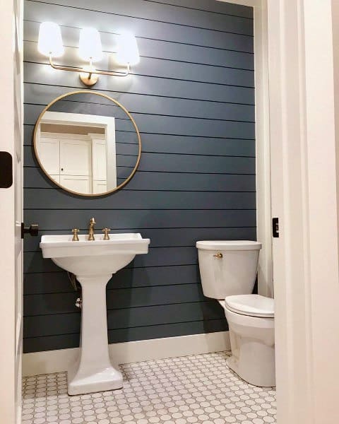 blue shiplap feature wall in small bathroom with white tile floor 
