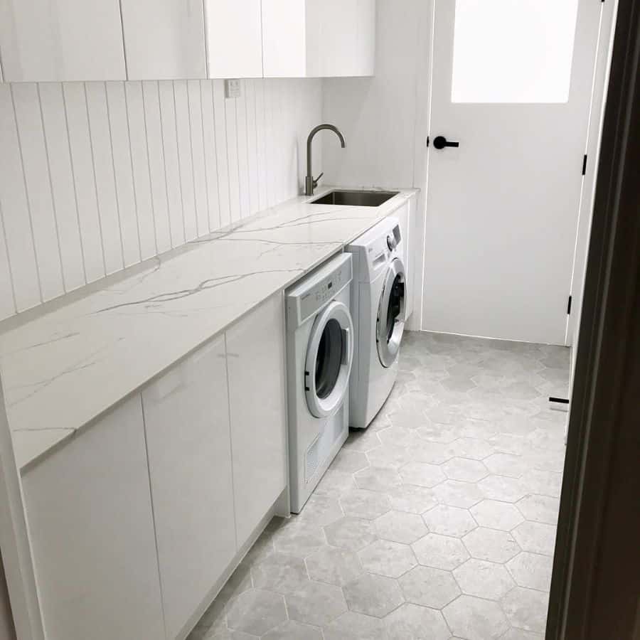 hallway laundry room white cabinets tile floor