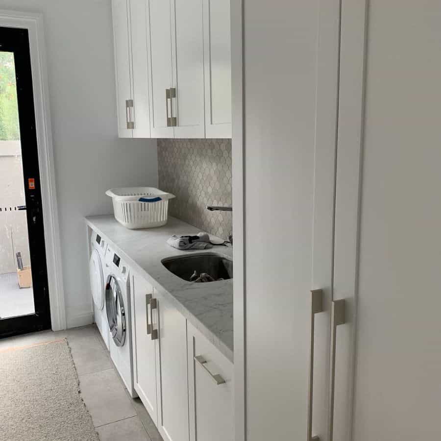 hallway laundry room white cabinets washer and dryer