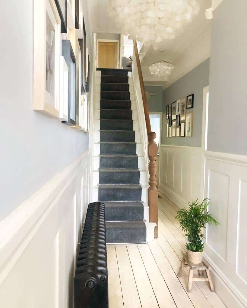 hallway gray carpet stairs wood banister 