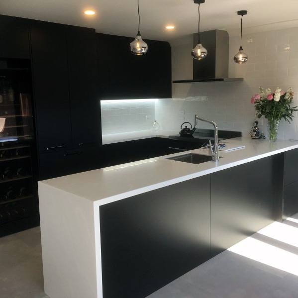 minimalist kitchen black cabinets white countertop track lighting 