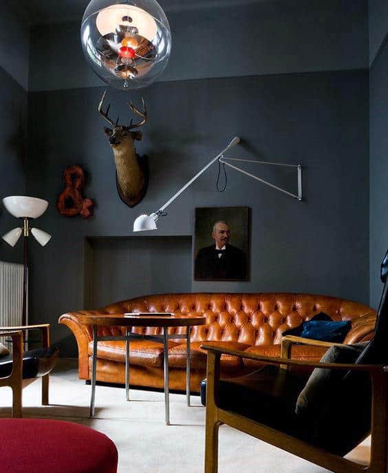 masculine living room with tan leather sofa and abstract wall decor 