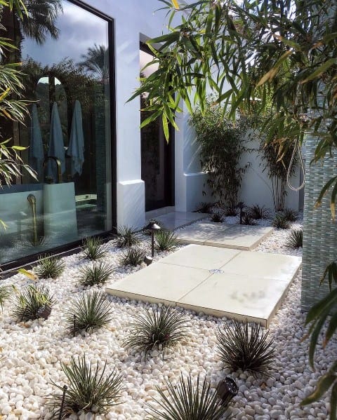 small white stone garden with desert plants and paver patio