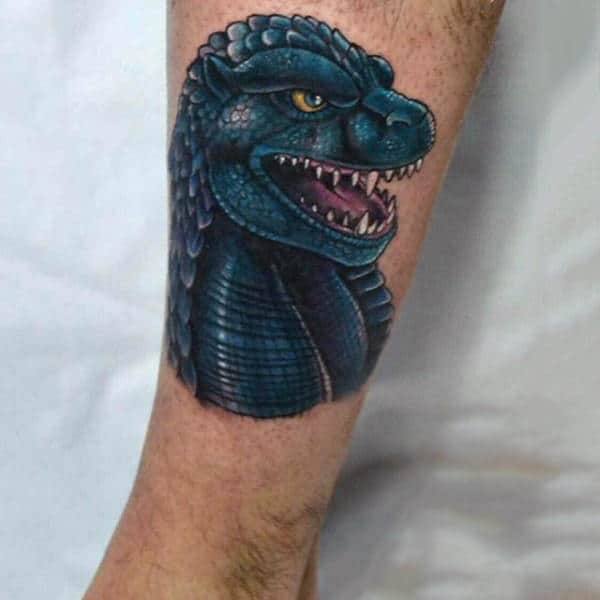 Illustrative Tattoo Of Godzilla On Mans Calf