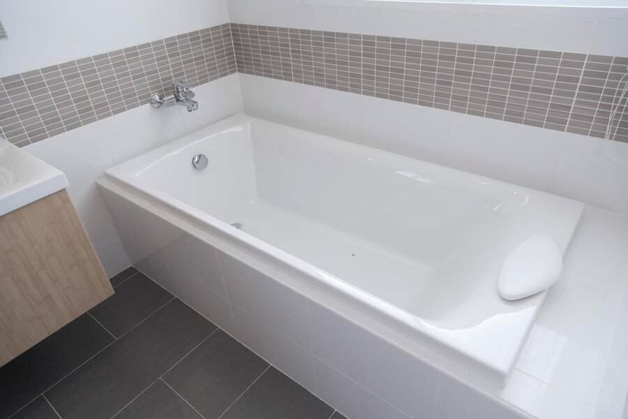Modern built-in bath with gray tile accents and a wall-mounted faucet for a sleek, minimalist look