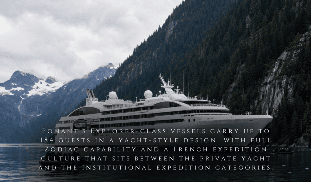 A white yacht-style cruise sails a mountain lake in Southeast Alaska, surrounded by peaks—private expeditions give remote access