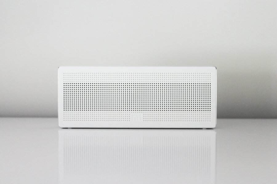 A white rectangular portable speaker rests on a shiny surface, resembling an HVAC tech’s tool, poised for conversation about short cycling