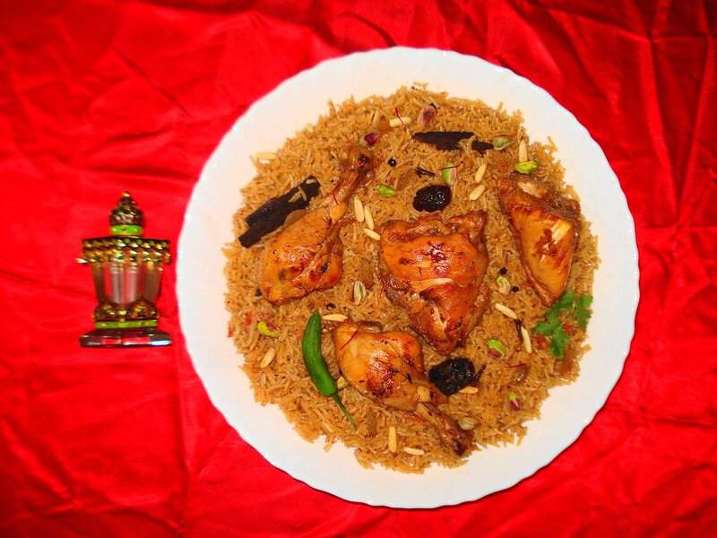 Chicken and rice with nuts and herbs on a red cloth, inspired by Al-Balad, perfect for your Jeddah trip