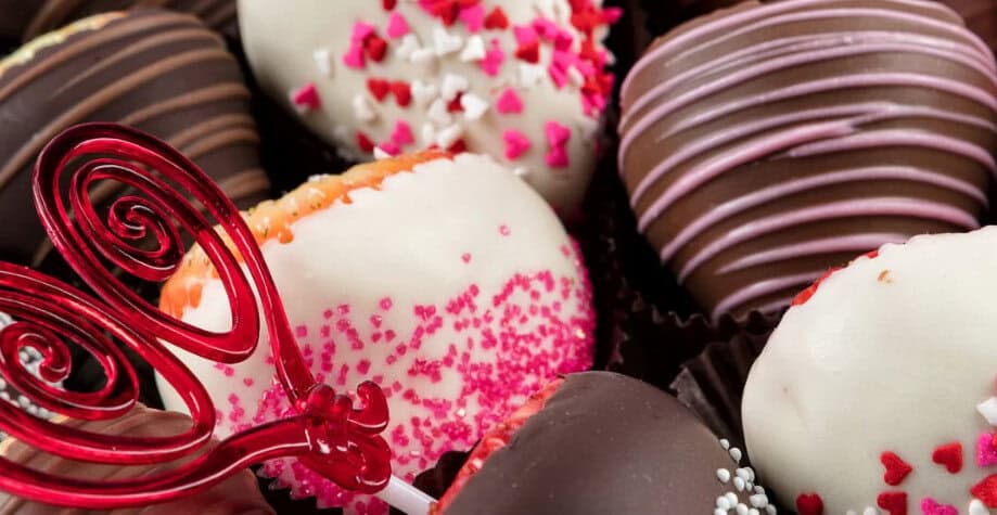 Assorted chocolate truffles and cake pops—perfect wedding desserts—decorated with colorful sprinkles and a red decorative pick