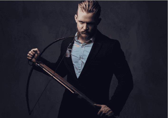 A serious man in a tuxedo holding a crossbow stands against a dark background, channeling a James Bond casino night vibe