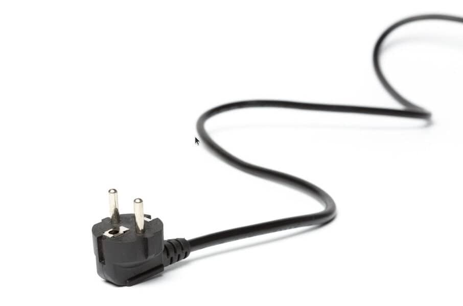 A black power plug with a long cord sits on a white background, highlighting its role in electrical safety
