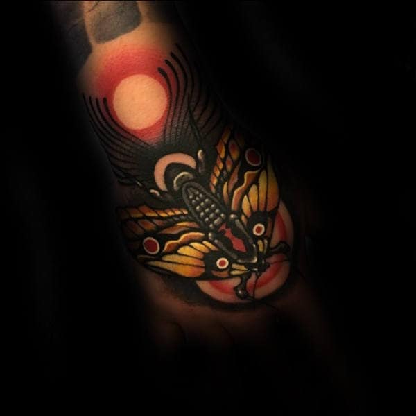 Incredible Guys Moth Hand Tattoo With Red Yellow And Black Ink Design