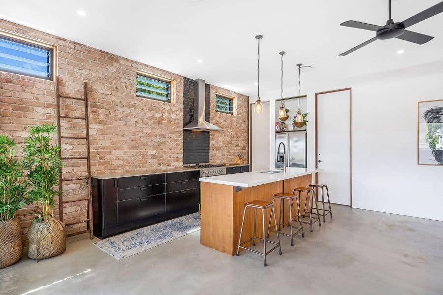 industrial kitchen design exposed brick wall cement floor pendant lights