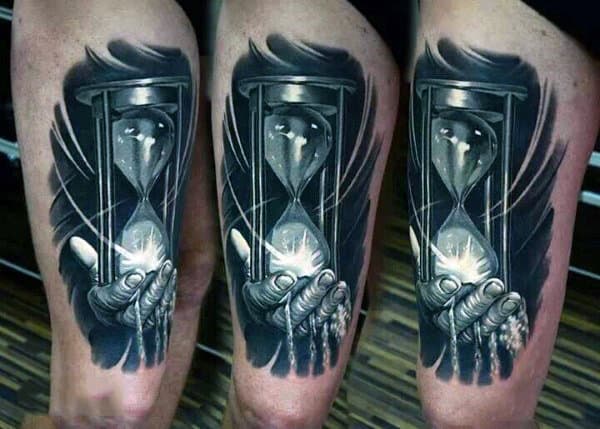 Innovative Hand With Sand Glass Realism Tattoo On Guys Thighs