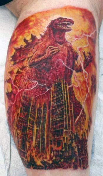 Intricate Godzilla Burning Down City Tattoo On Mans Calf