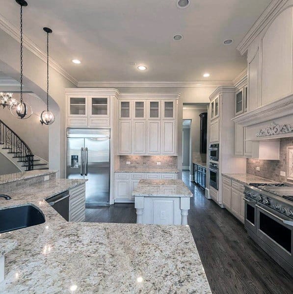 large open modern kitchen with white cabinets and marble countertops 