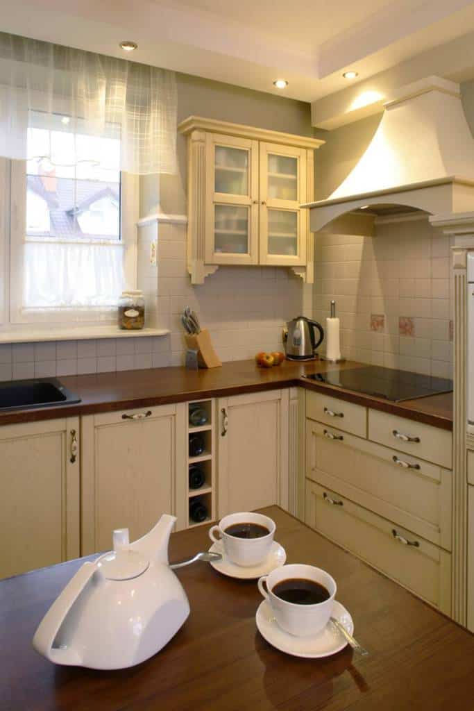 small corner kitchen white cabinets brown kitchen bench top teapot 